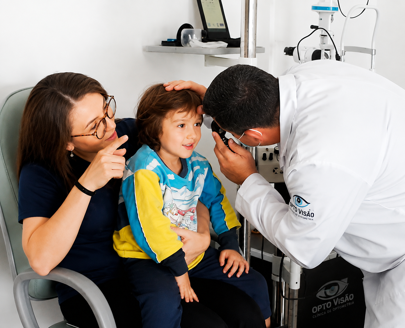 Optometrista atendendo criança acompanhada da mãe na OPTO VISÃO